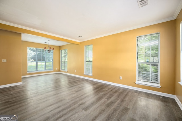 spare room featuring hardwood / wood-style floors, ornamental molding, and a notable chandelier