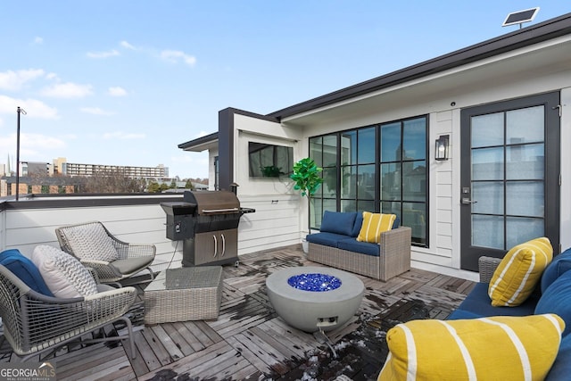 wooden deck featuring an outdoor living space with a fire pit and a grill