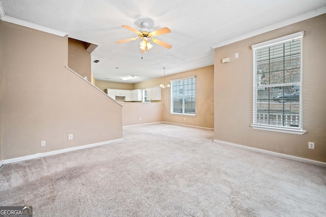 unfurnished living room featuring light carpet, ceiling fan with notable chandelier, crown molding, and a textured ceiling