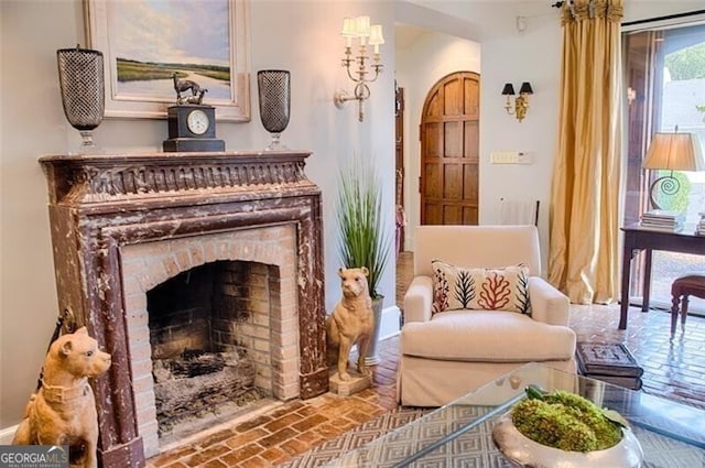 sitting room with brick floor and a brick fireplace