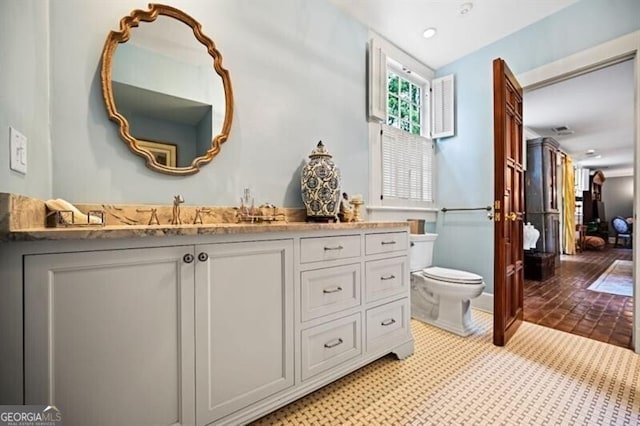 bathroom with vanity, toilet, and recessed lighting