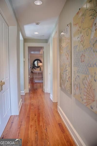 corridor featuring baseboards and light wood-style floors