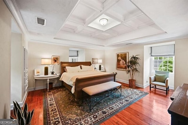 bedroom featuring coffered ceiling, visible vents, baseboards, and wood finished floors