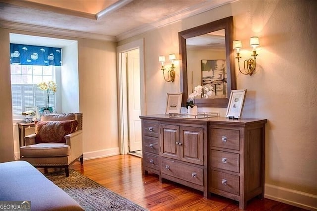 living area with baseboards, ornamental molding, and wood finished floors