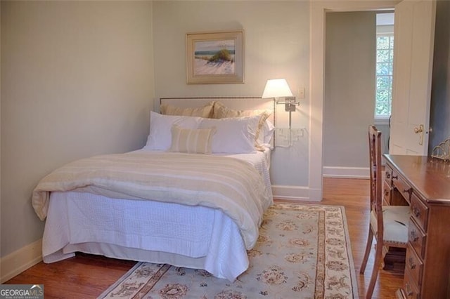 bedroom with baseboards and wood finished floors