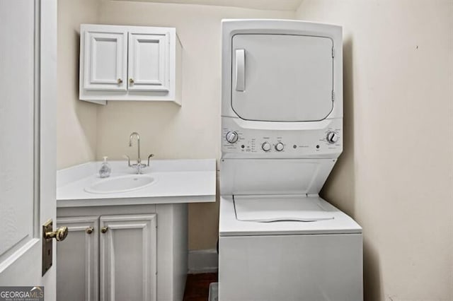 laundry area featuring stacked washing maching and dryer, laundry area, and a sink