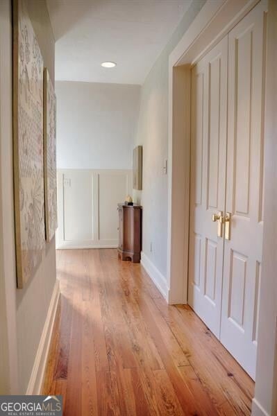 corridor featuring baseboards and wood finished floors