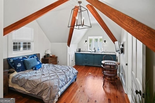 bedroom featuring vaulted ceiling with beams, hardwood / wood-style flooring, and a sink