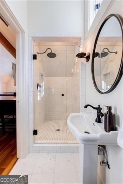 bathroom featuring marble finish floor, a shower stall, and visible vents