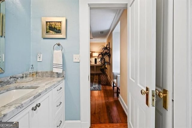 bathroom featuring wood finished floors, vanity, and baseboards