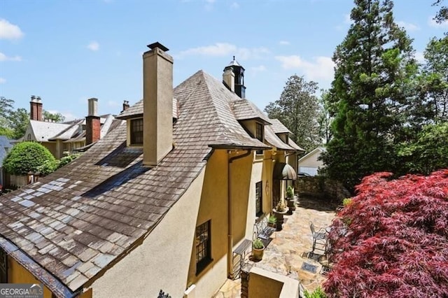 exterior space featuring a chimney and stucco siding