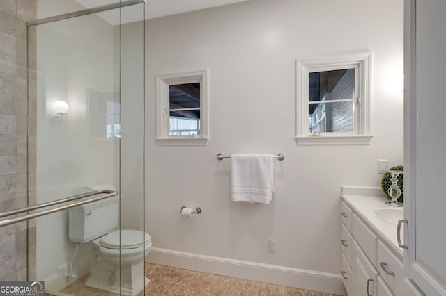 bathroom with toilet, an enclosed shower, and vanity