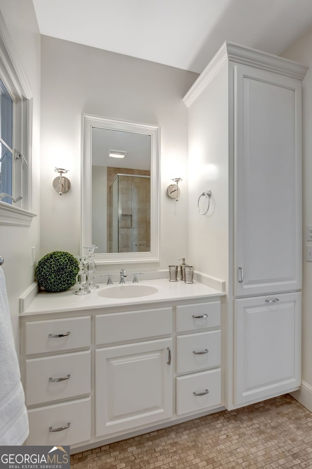 bathroom with a shower with door and vanity