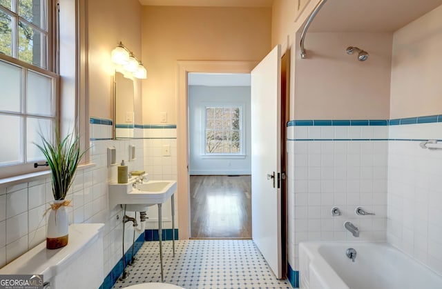 bathroom with tile walls and a bathtub