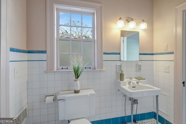 bathroom featuring toilet and tile walls