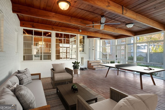 sunroom with ceiling fan and beamed ceiling