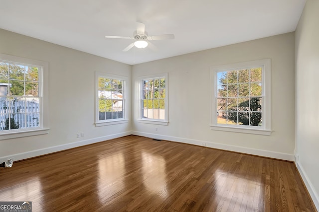 spare room with wood-type flooring, ceiling fan, and plenty of natural light