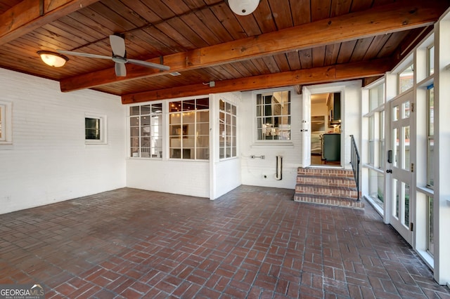 unfurnished sunroom featuring beam ceiling, wood ceiling, and ceiling fan