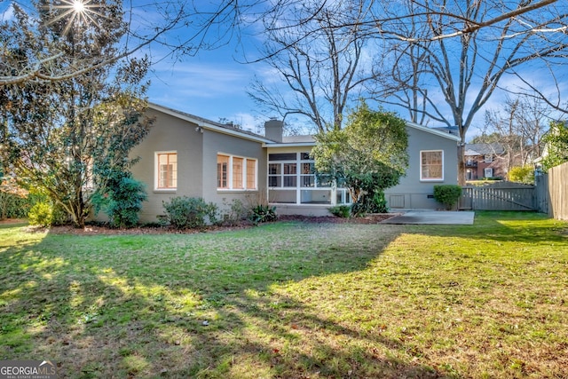 view of front of house with a front yard, a patio, and a sunroom