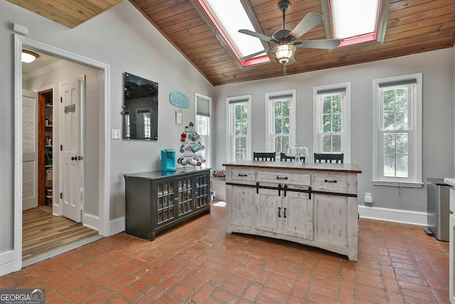 kitchen featuring ceiling fan, lofted ceiling with skylight, and wood ceiling