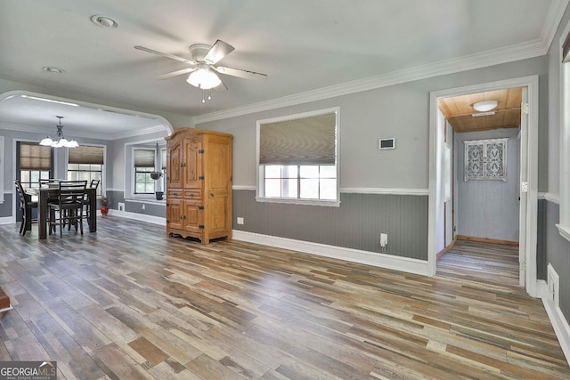 living room featuring ceiling fan with notable chandelier, crown molding, and wood-type flooring