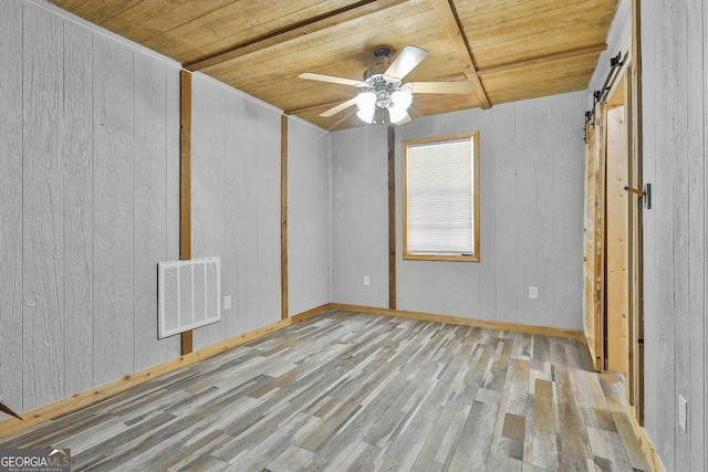 unfurnished room with wooden ceiling, light wood-type flooring, ceiling fan, and a barn door