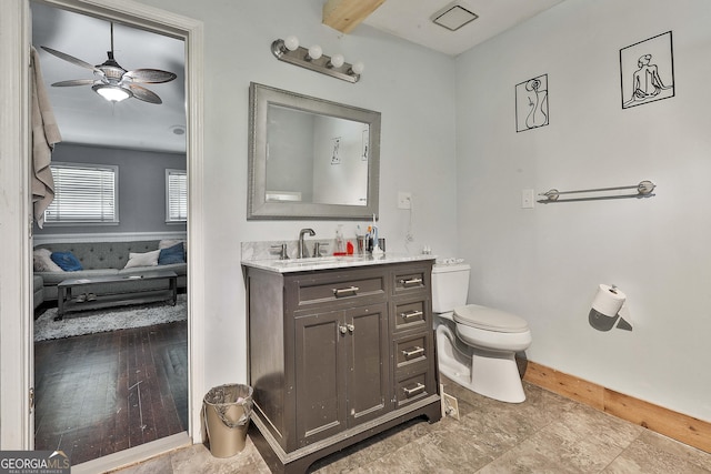 bathroom with toilet, vanity, and ceiling fan