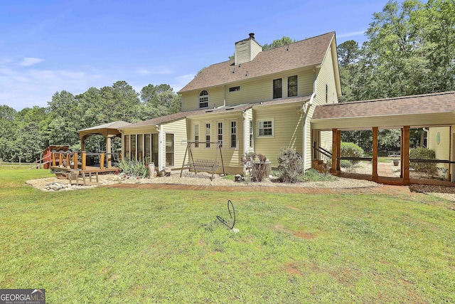 rear view of property with a lawn and a wooden deck