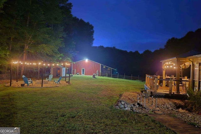 yard at twilight featuring a storage unit and a deck