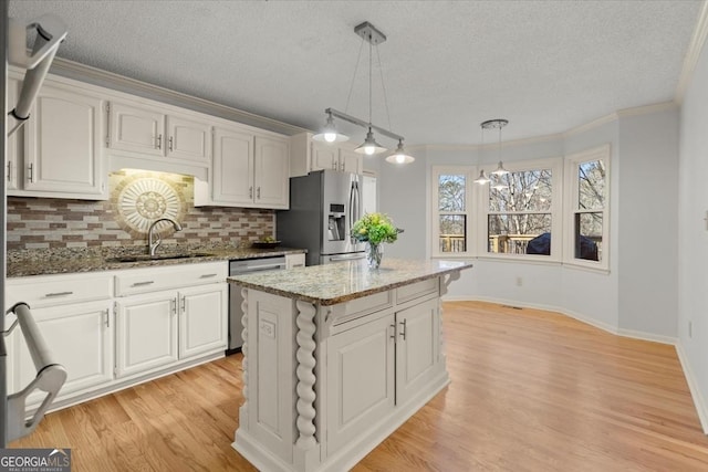 kitchen featuring sink, white cabinetry, a center island, and appliances with stainless steel finishes