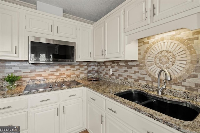 kitchen with decorative backsplash, sink, and white cabinets