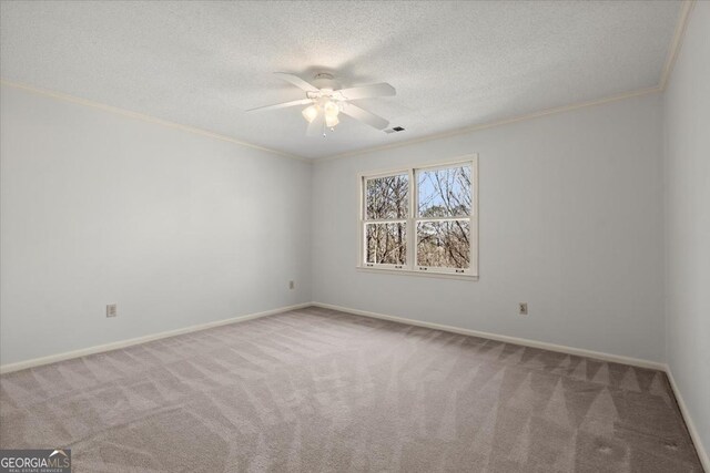 carpeted spare room with a textured ceiling, ceiling fan, and ornamental molding