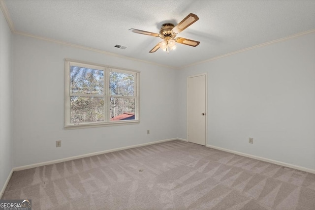 carpeted spare room featuring ceiling fan, crown molding, and a textured ceiling