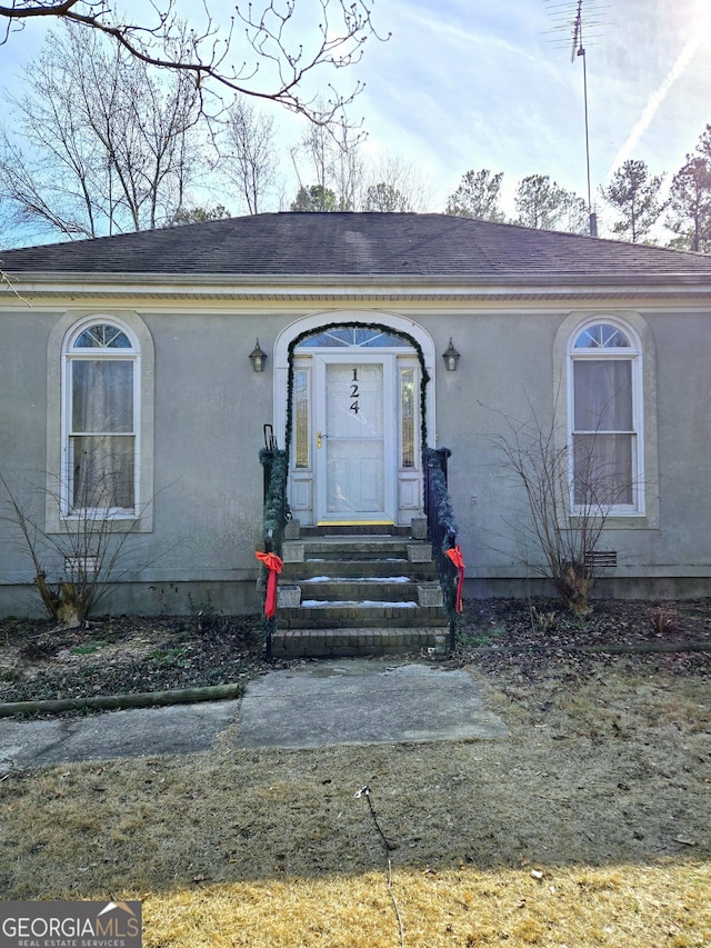 view of front of house featuring entry steps and stucco siding