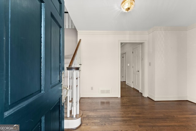 foyer entrance featuring crown molding and dark wood-type flooring