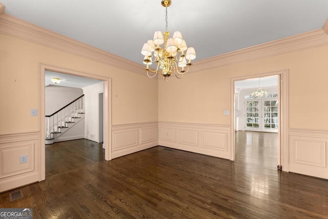 unfurnished dining area featuring crown molding, dark hardwood / wood-style floors, and a chandelier