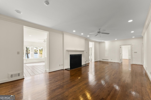 unfurnished living room with crown molding, dark wood-type flooring, and ceiling fan