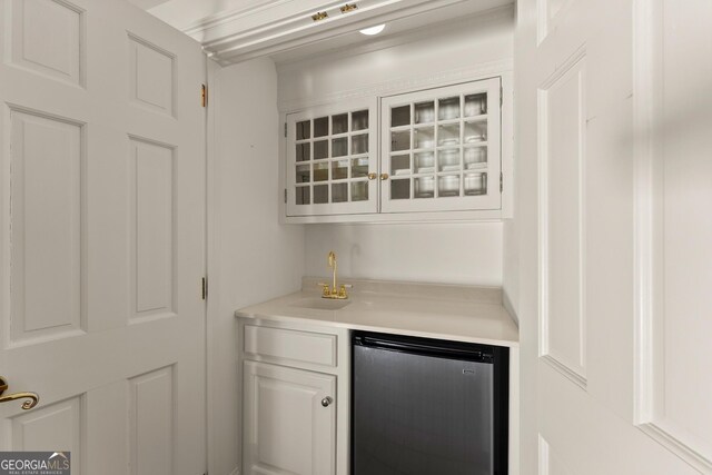 bar featuring white cabinetry, sink, and stainless steel fridge