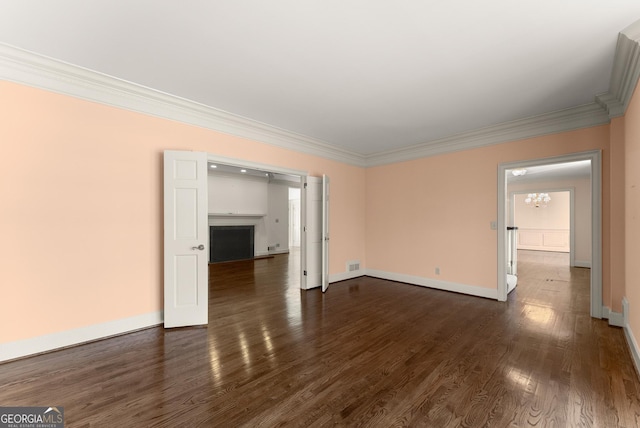 spare room featuring crown molding and dark hardwood / wood-style flooring