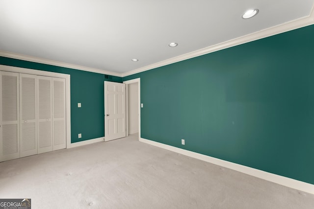 unfurnished bedroom with ornamental molding, light carpet, and a closet