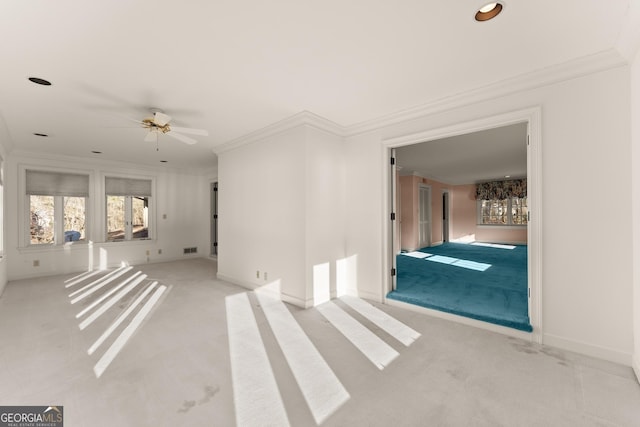 carpeted spare room featuring ceiling fan and ornamental molding