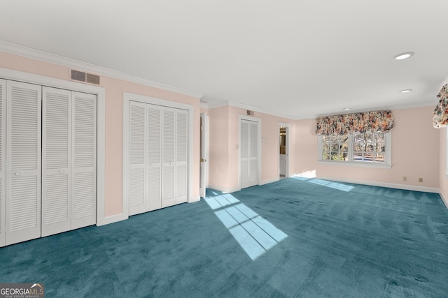 unfurnished living room with crown molding and dark colored carpet