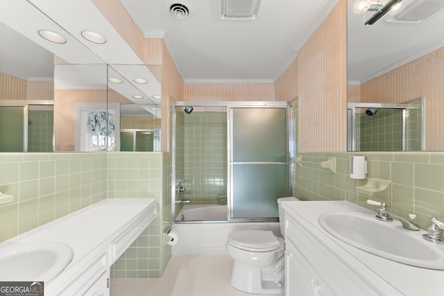 full bathroom featuring toilet, ornamental molding, bath / shower combo with glass door, and tile walls