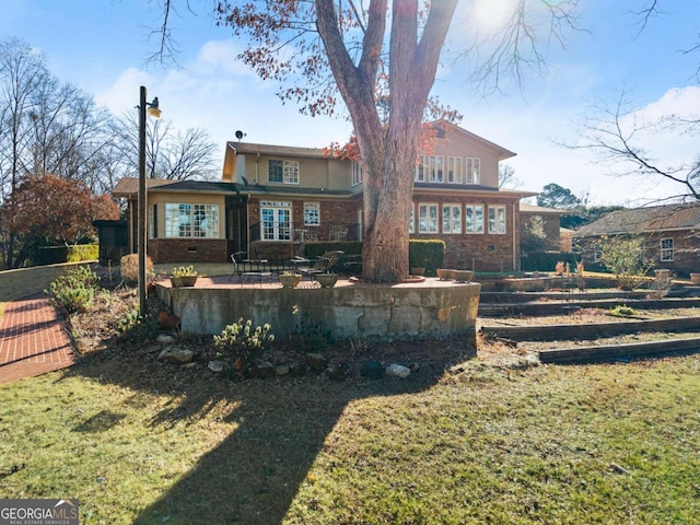 rear view of house featuring a patio and a lawn