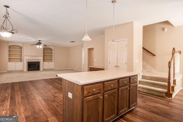 kitchen featuring a kitchen island, ceiling fan, pendant lighting, and built in features