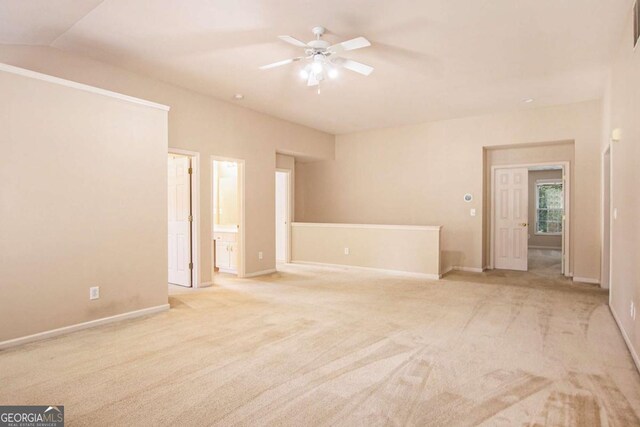 spare room with lofted ceiling, ceiling fan, and light carpet