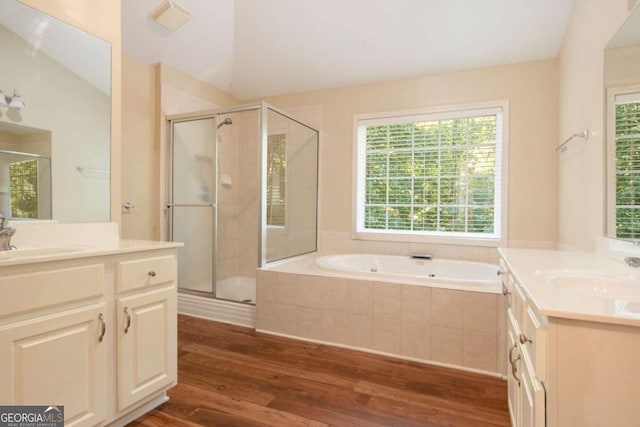 bathroom with plus walk in shower, vaulted ceiling, vanity, and hardwood / wood-style floors