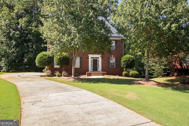 obstructed view of property with a front lawn