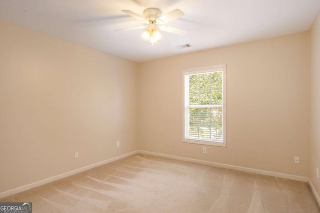 empty room with ceiling fan and light carpet