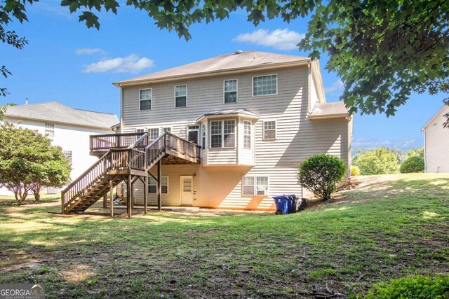 rear view of property featuring a yard and a deck